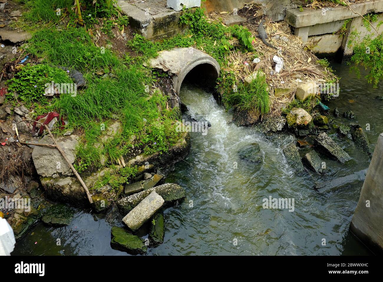 Wastewater Flows from Sewer to Canal, Environmental Degradation Concept. Stock Photo