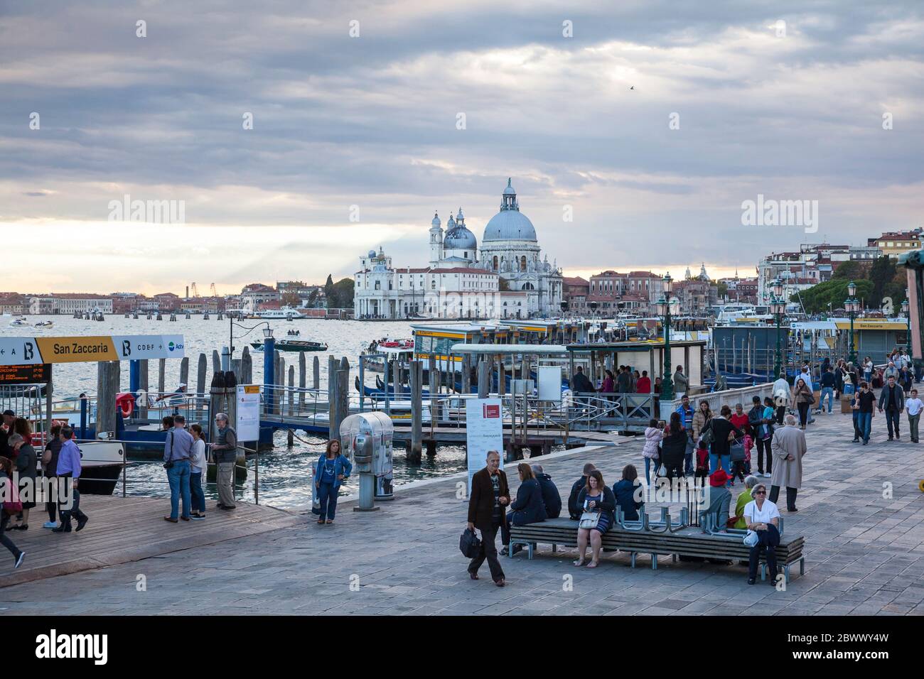 Busy waterbus stops along the Riva degli Schiavoni in Venice, Italy with the Basilica Santa Maria della Salute in the background Stock Photo