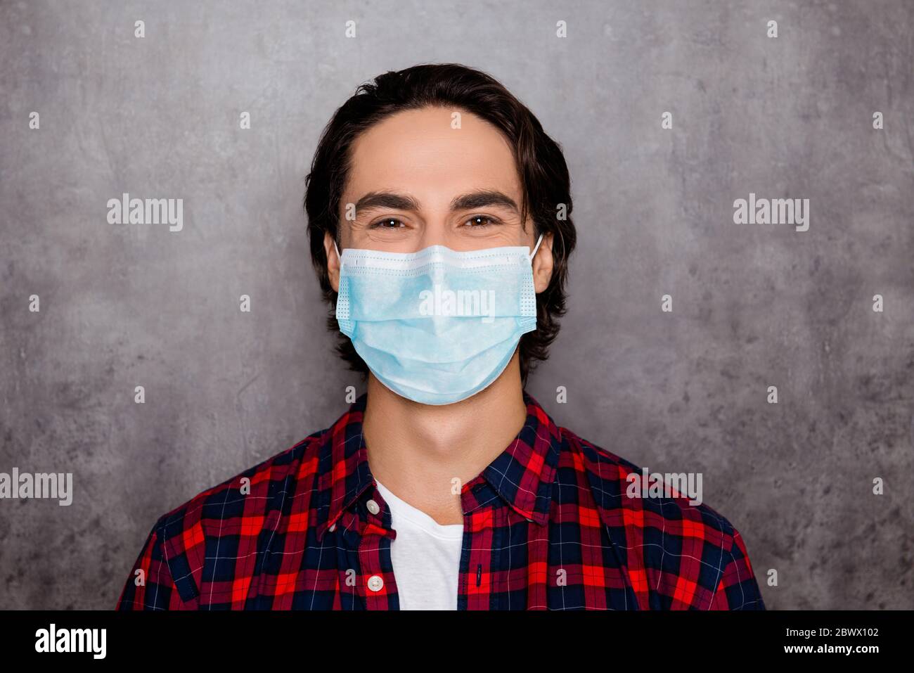 Close-up portrait of his he attractive cheery brunette healthy guy wearing reusable respirator gauze mask co2 cov air pollution isolated over dark Stock Photo