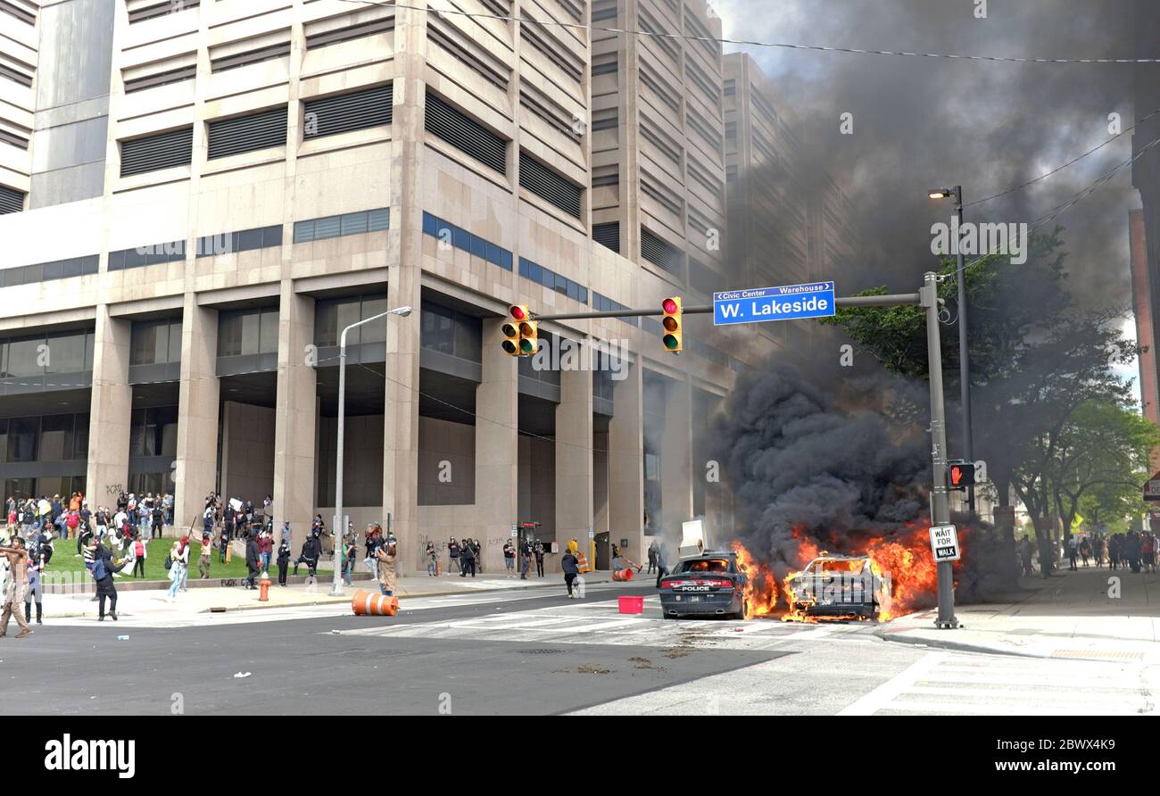 Two Cleveland police cars burn on the street outside the Justice Center where violent protests resulted in a curfew in downtown Cleveland, Ohio, USA.  Thousands of protesters demonstrated in front of the Justice Center in response to the killing of George Floyd at the hands of police in Minneapolis.  After a peaceful march turned violent on the steps of the Justice Center, looting, starting of fires, and mass vandalism plagued the downtown area as police anticipated 300 protesters but in reality was estimated to be over 3000. Stock Photo