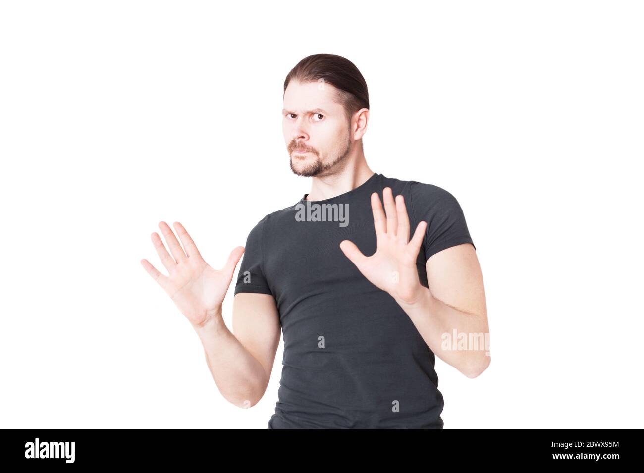 A young man shows a stop gesture. In studio isolated on a white background. Stock Photo
