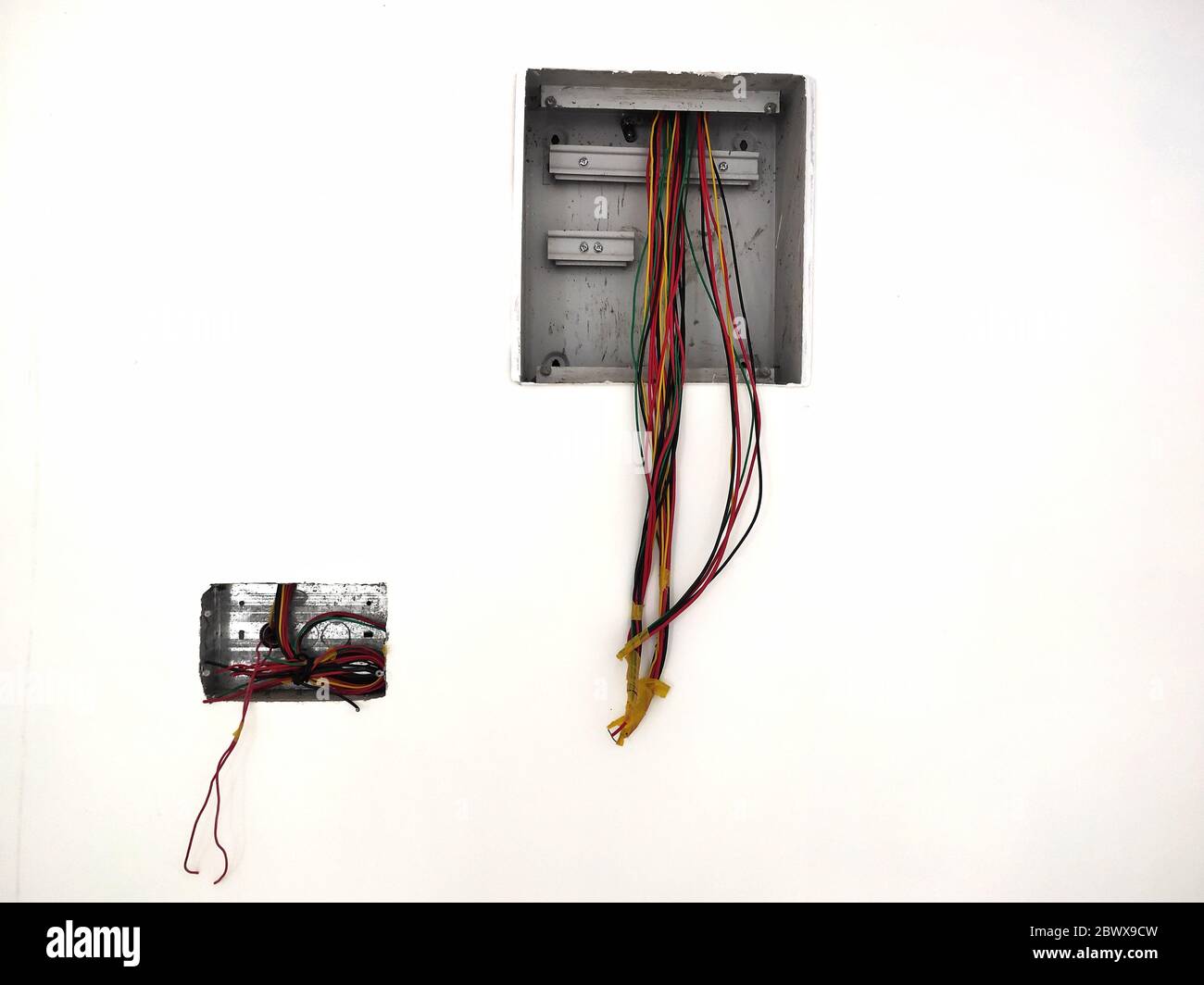 unfinished electrical steel junction box on white brick wall. Household electric installation