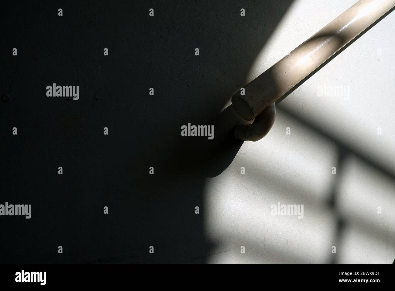 Handrail on Grunge Concrete Wall Background with Shadows. Stock Photo