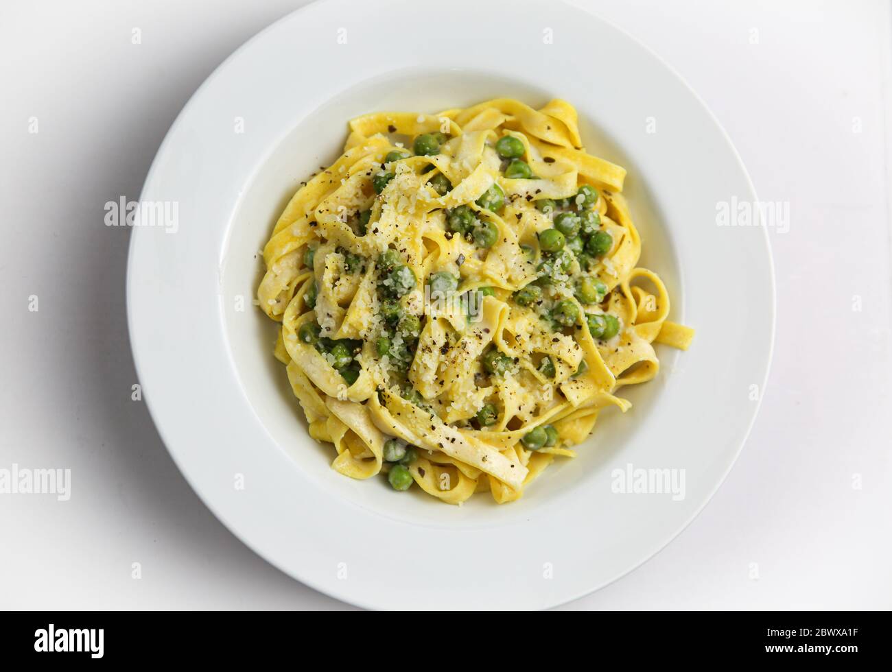 Tagliatelli con Limone e Piselli on white plate Stock Photo