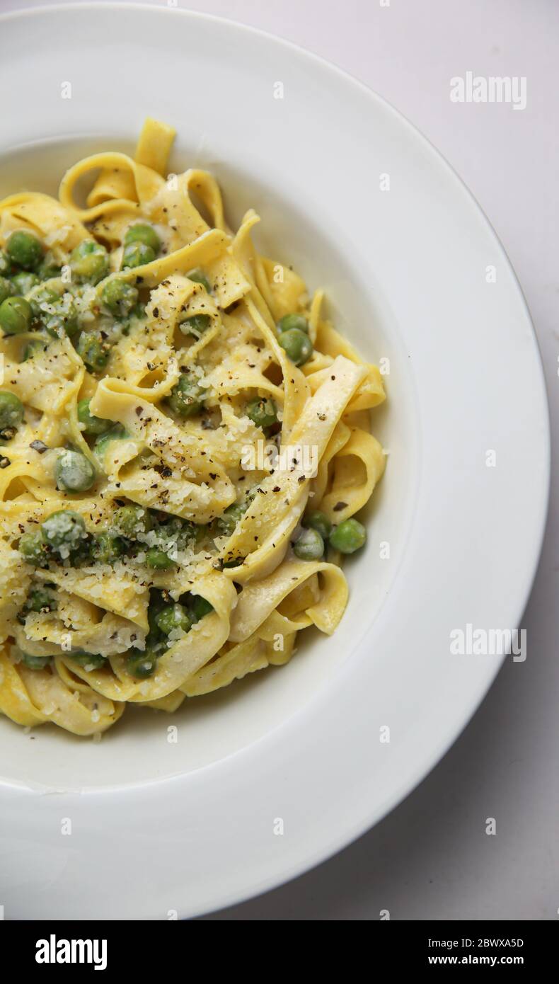 Tagliatelli con Limone e Piselli on white plate corner view Stock Photo