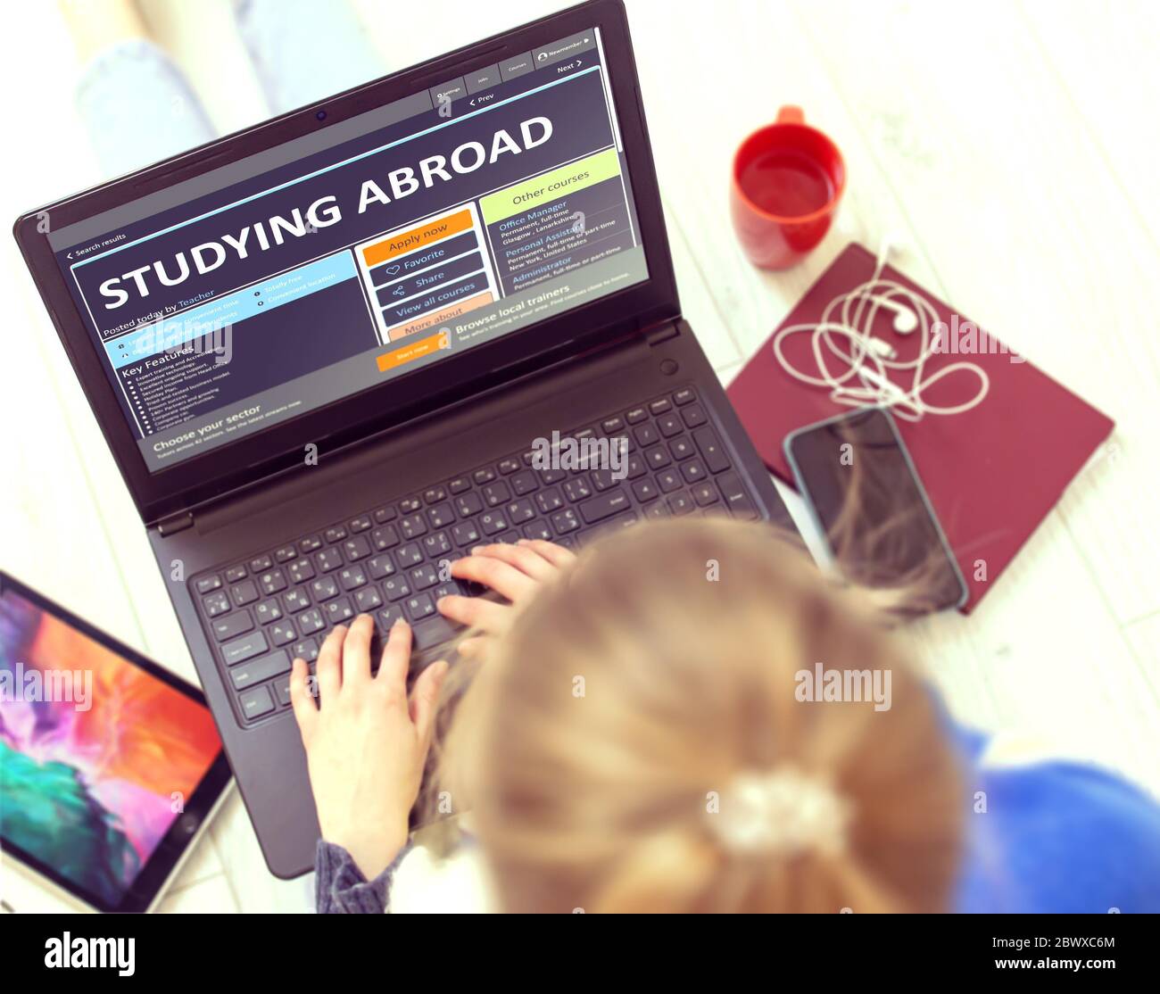 Studying Abroad. Close-up Of Young Woman Using Laptop on the Floor. Continuing Education Concept. Stock Photo