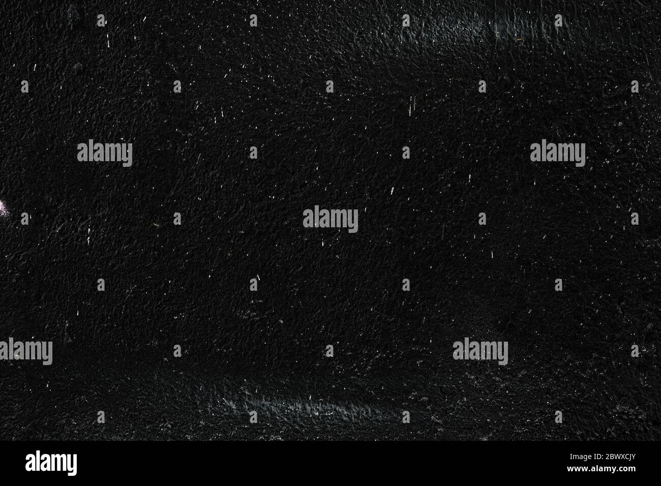 White Paint Splatters on Black Concrete Wall Texture Background. Stock Photo