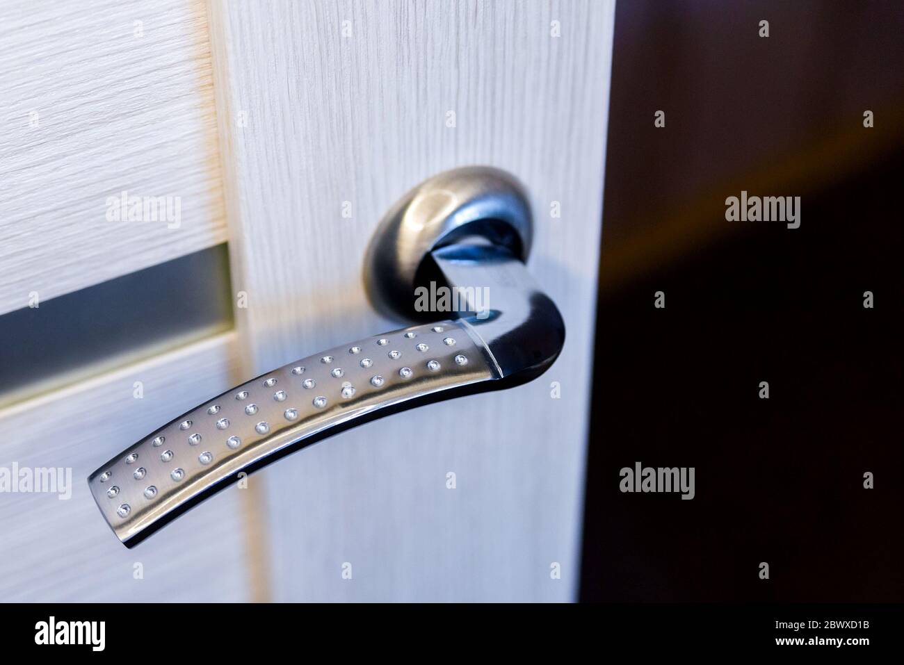 Closeup of metal doorhandle on wooden door Stock Photo