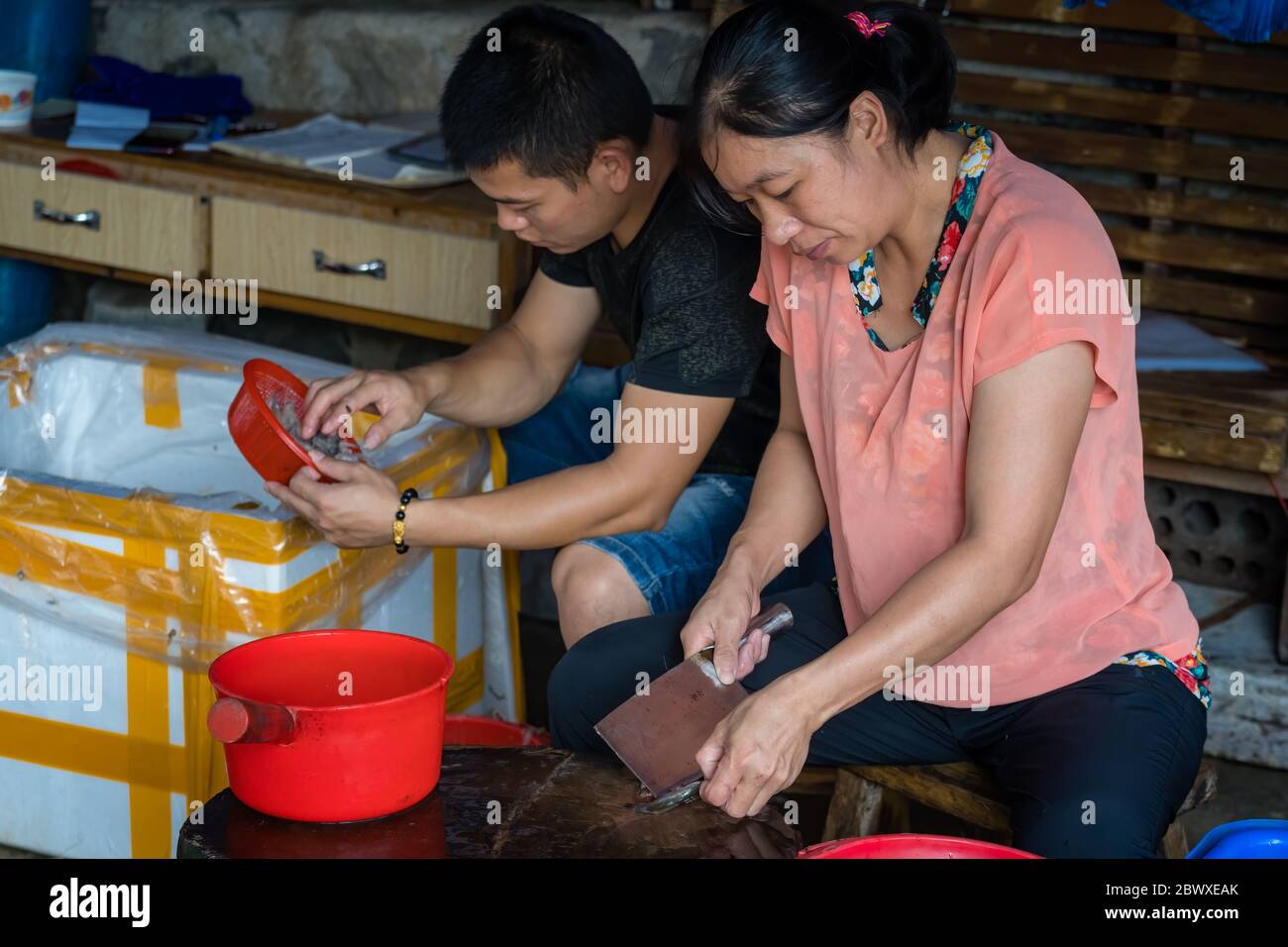 Yangshuo, China August 2019 Chinese male and female workers peeling