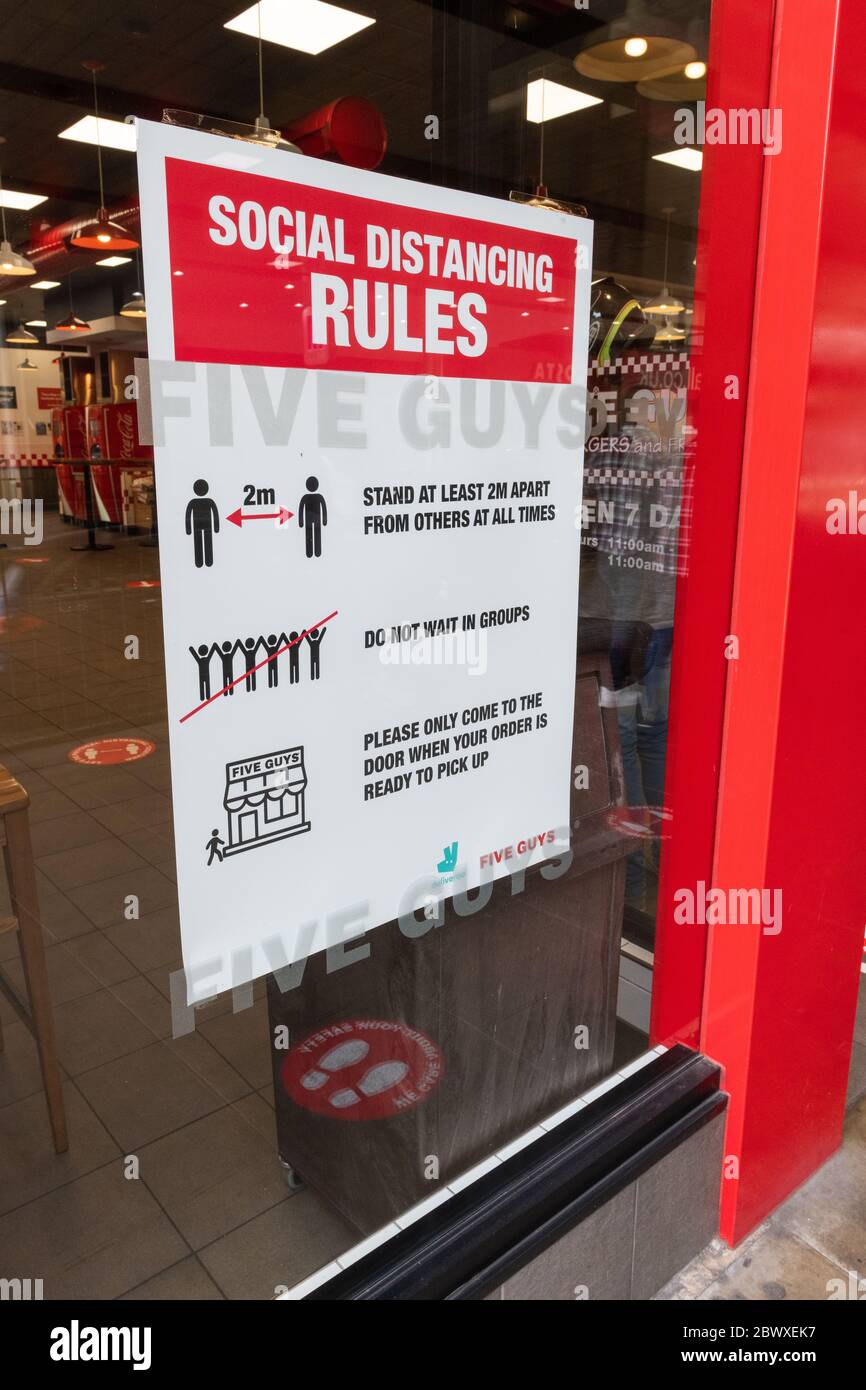 A customers' notice in the window of a fast food restaurant detailing the social distancing rules for shops as required under government lockdown. Stock Photo