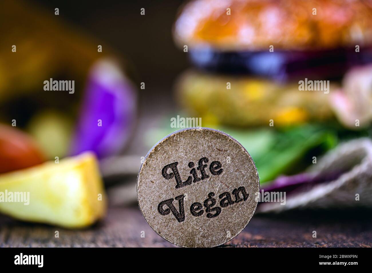 small wooden sign with the English phrase: Vegan life. Concept of vegan food, vegetarian lifestyle or change in eating habits. Stock Photo
