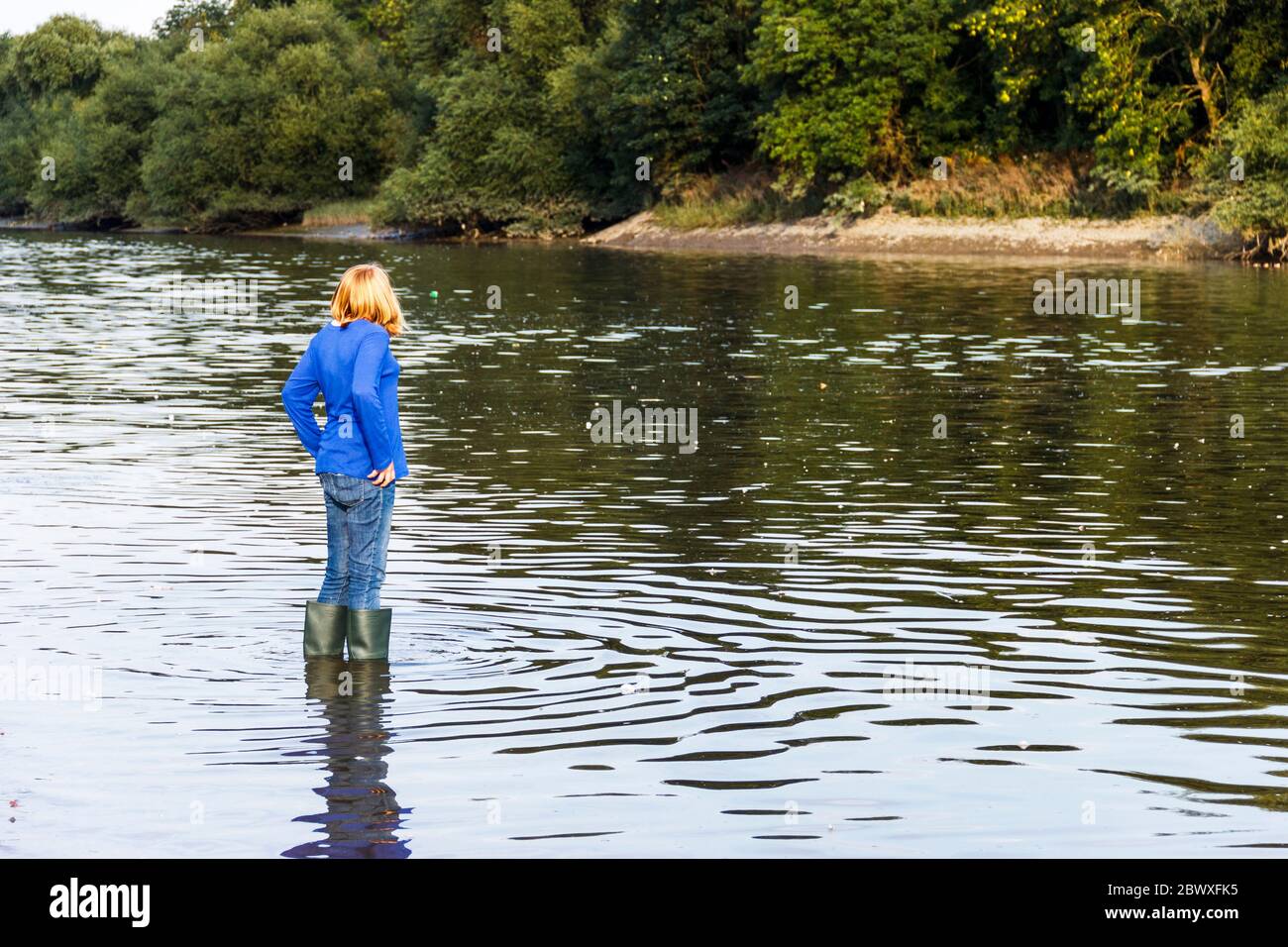 A thirteen yearold girl in wellington boots wading in the River Thames