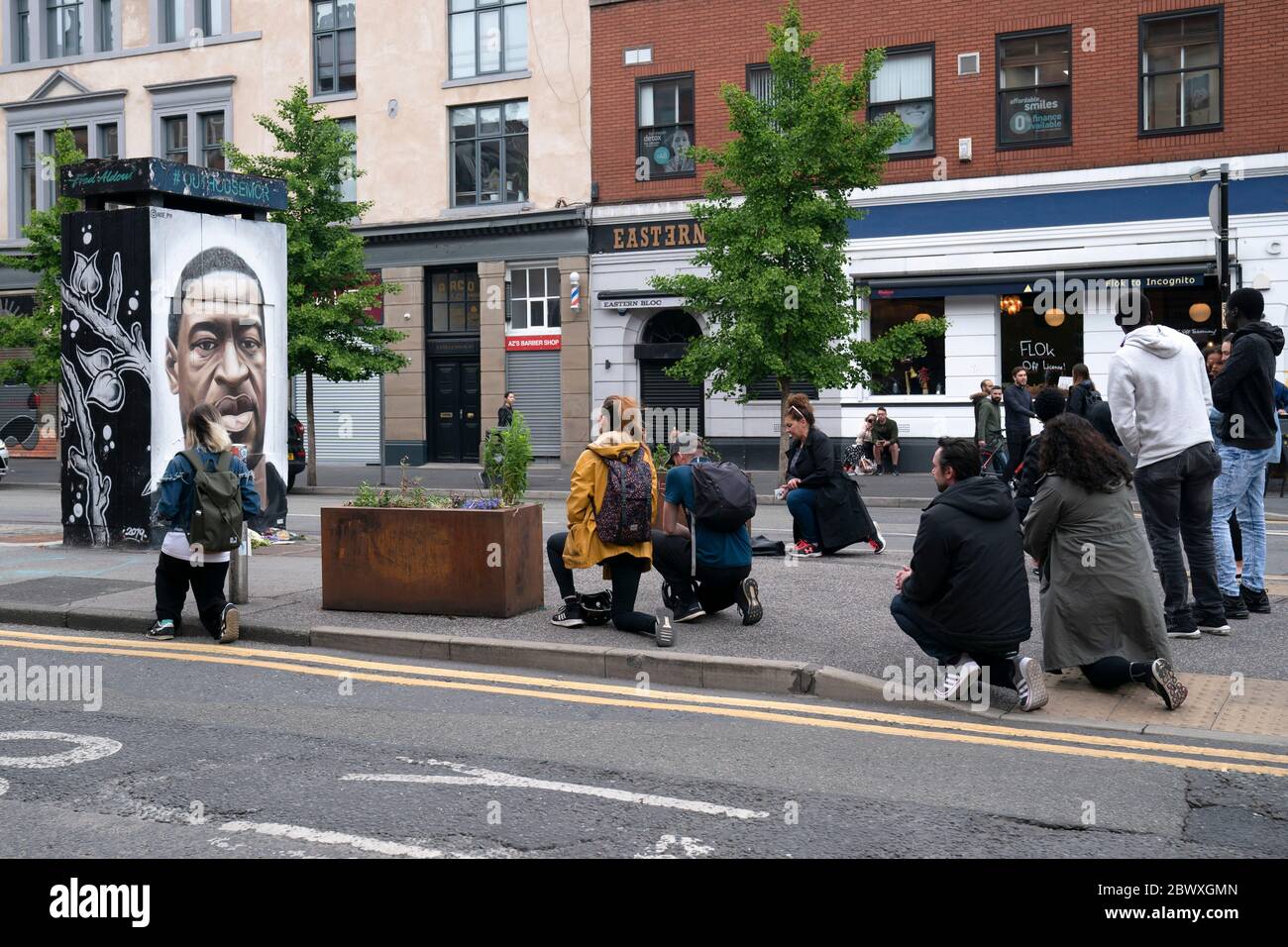 Manchester, UK. 3rd June, 2020. Members of the public some taking the knee are seen by a mural of George Floyd the 46-year-old black man who died in Minneapolis, Minnesota on May 25th after Derek Chauvin, a white officer with the Minneapolis Police Department, pressed his knee to Floyd's neck, Manchester, UK. Credit: Jon Super/Alamy Live News. Stock Photo