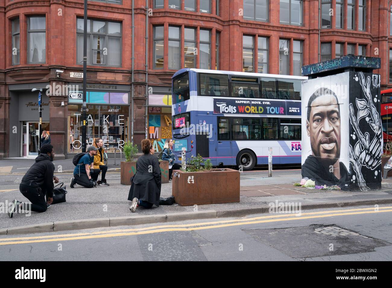Manchester, UK. 3rd June, 2020. Members of the public take the knee by a mural of George Floyd the 46-year-old black man who died in Minneapolis, Minnesota on May 25th after Derek Chauvin, a white officer with the Minneapolis Police Department, pressed his knee to Floyd's neck, Manchester, UK. Credit: Jon Super/Alamy Live News. Stock Photo