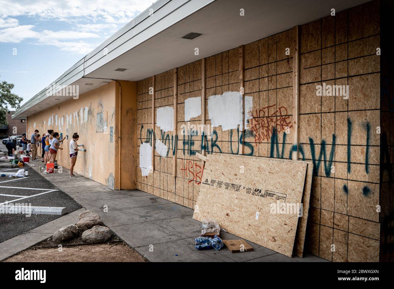 Minneapolis, Minnesota / USA - June 2 2020: Volunteers clean up graffiti on damaged and wrecked building with haunting 'Can you hear us now' graffiti Stock Photo