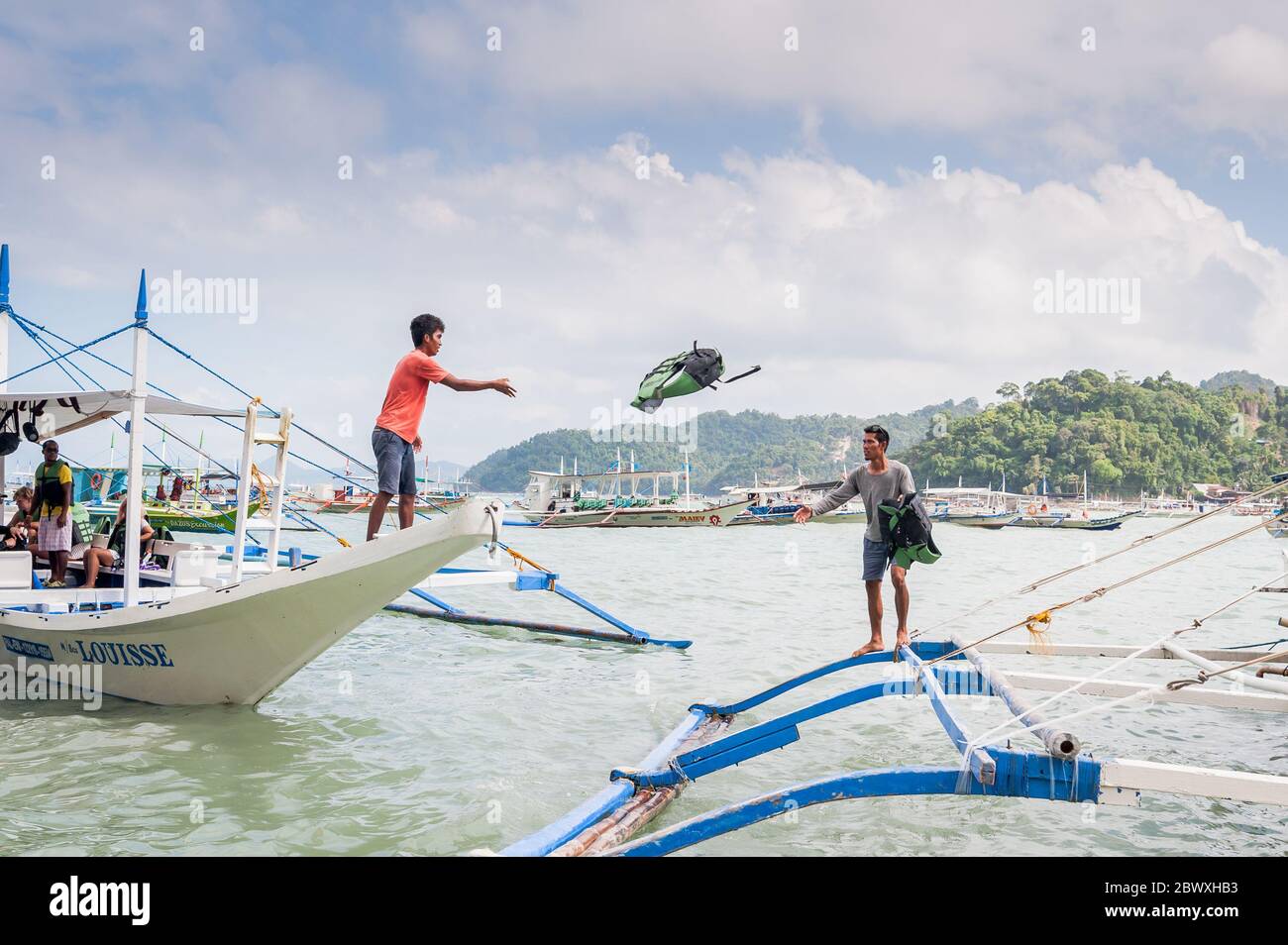 Boat captains and their help set up the long tail boats that take the tourists out to the lagoons, beaches and Islands around El Nido, Palawan, The Ph Stock Photo