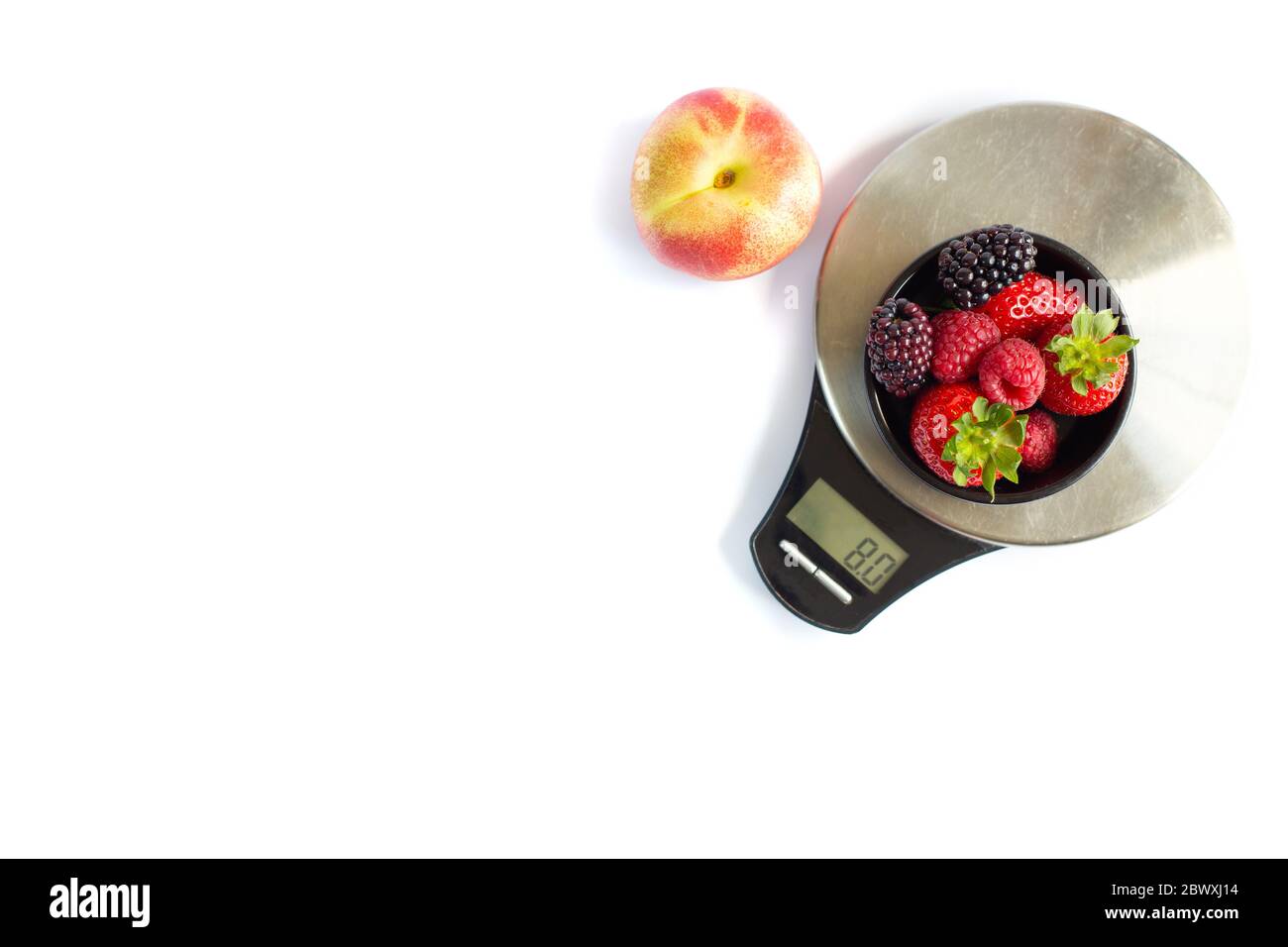 Black round plate with red black summer berries, apple and digital scale weight. Self weight control, diet, vegetarian concept Stock Photo