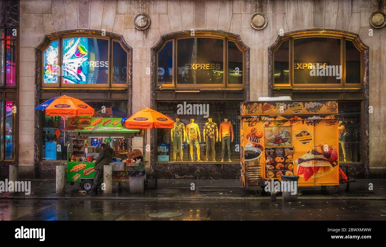 New York City, USA, May 2019, street vendor in front of an Express clothing store at the corner of the 46th St and Broadway on a rainy day Stock Photo
