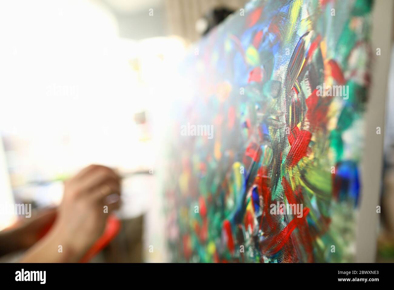 Man paints large bright abstract painting picture Stock Photo