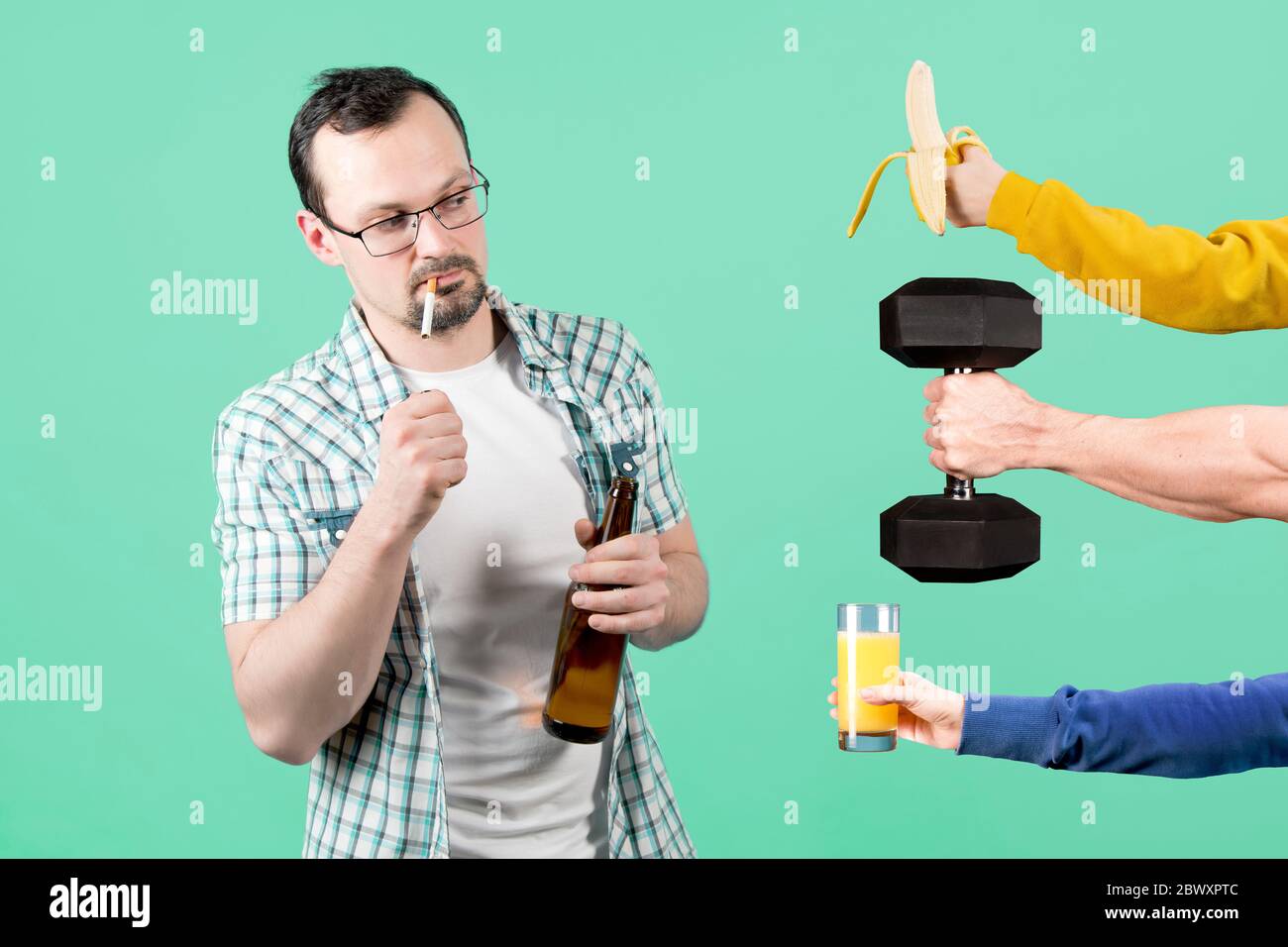 A man lights a cigarette with a bottle of beer in his hand, and at this time he is offered healthy food and sports. smoky man holding banana, juice an Stock Photo