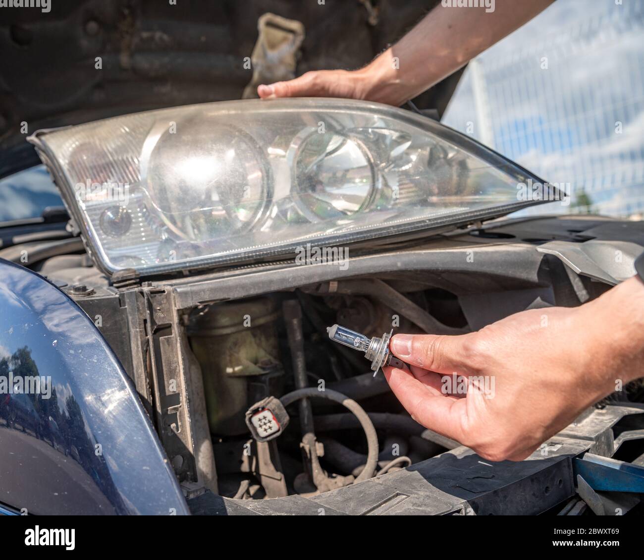 car headlight repair by replacing bad bulbs with new ones Stock Photo