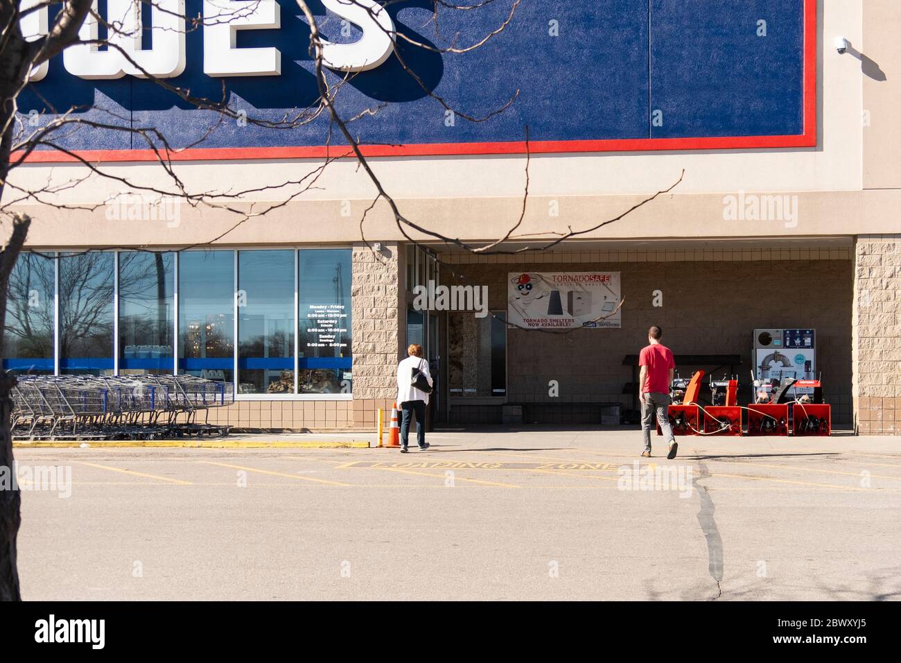Two shoppers, a man and a woman, walk toward Lowe's Home Improvement store entrance. Wichita, Kansas, USA. Stock Photo