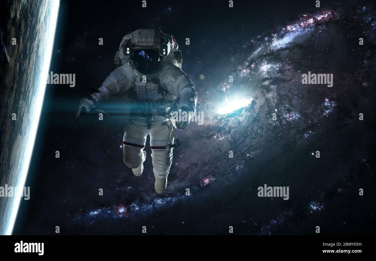 Astronaut and planet against a blue galaxy Stock Photo