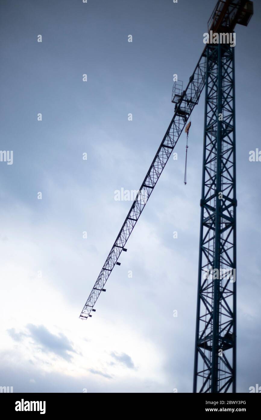 Tower crane with dark blue sky at twilight. Vertical shot