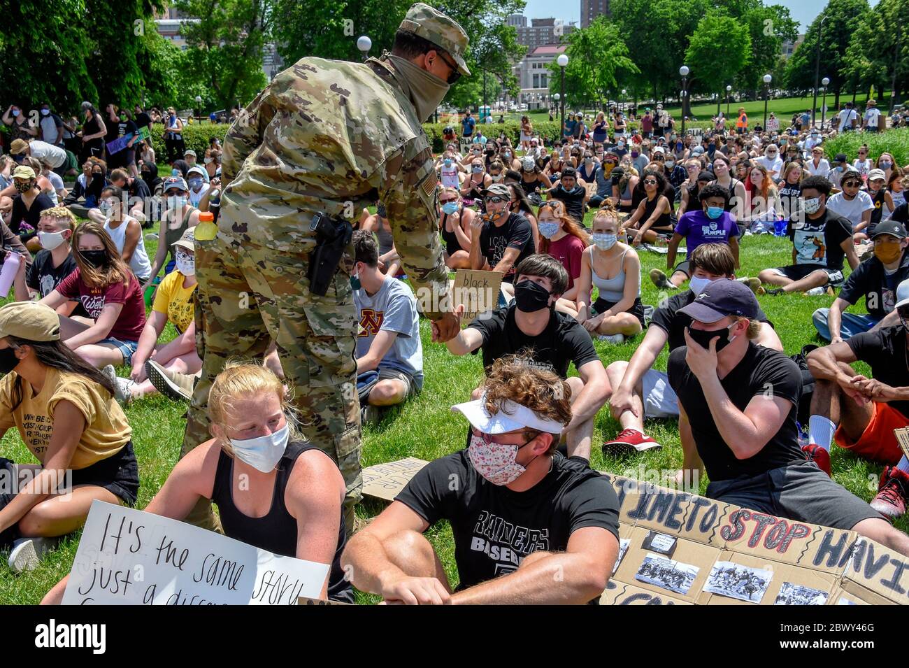 Minnesota National Guardsmen walk through a crowd of peaceful ...