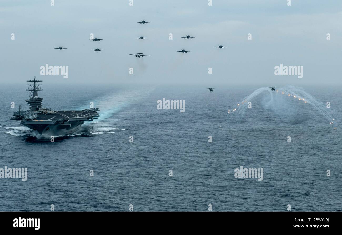 U.S. Navy Aircraft from Nimitz Carrier Strike Group fly in formation over the aircraft carrier USS Nimitz underway conducting composite training unit exercise June 2, 2020 in the Pacific Ocean. Stock Photo