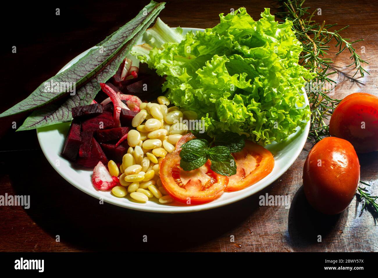 Vegan food. Plate of lettuce, beet, fava and tomato Stock Photo