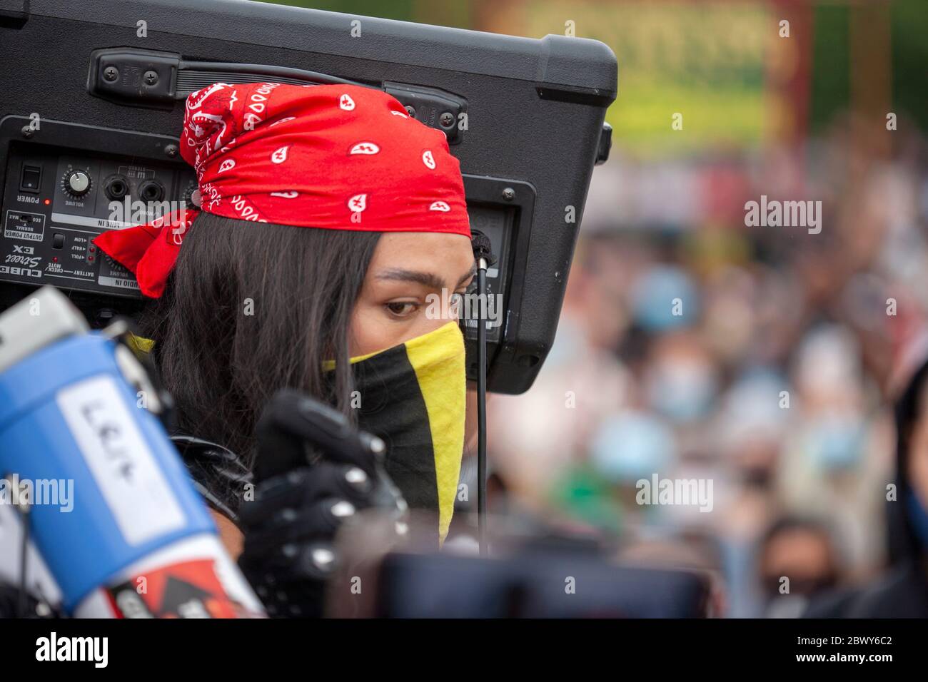 Young woman, wearing a protective face scarf and a red bandana, holding up  an amp, during the Black Lives Matter UK protest march. London, England, UK  Stock Photo - Alamy