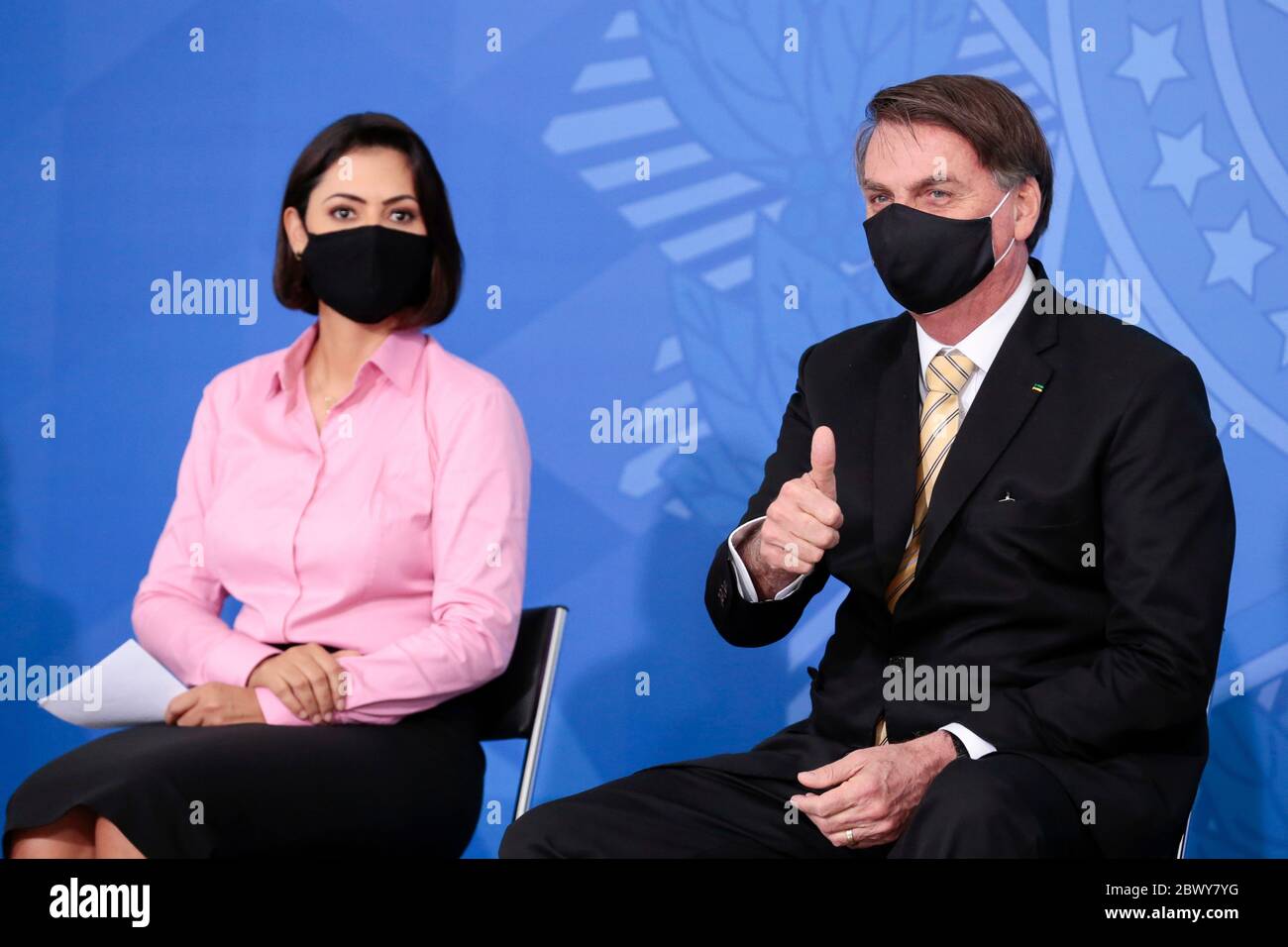 Brazilian President Jair Bolsonaro and first lady Michelle Bolsonaro, both wearing masks amid the COVID-19 pandemic, during an event promoting a government campaign against domestic violence at Planalto presidential palace May 15, 2020 in Brasilia, Brazil. Stock Photo