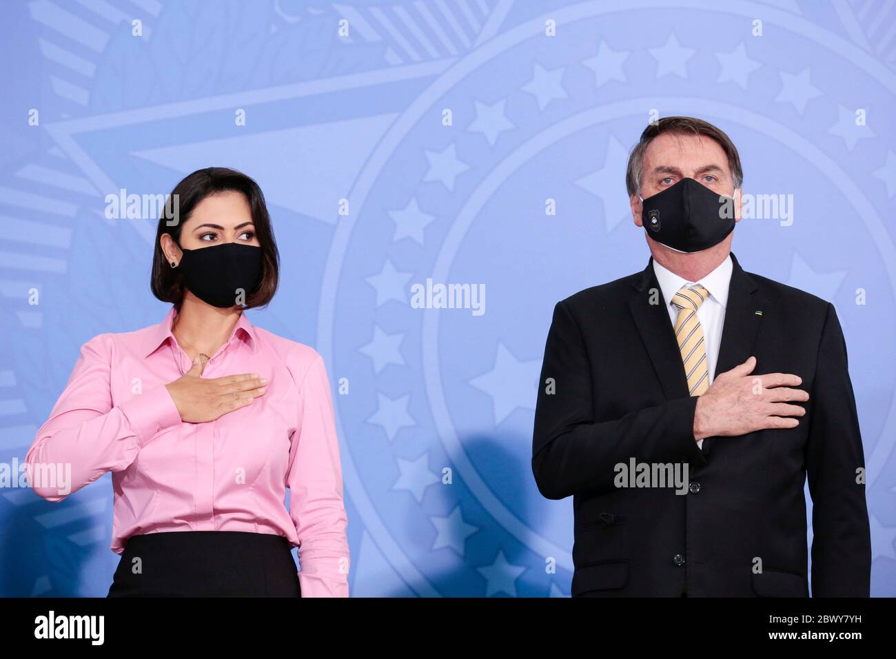 Brazilian President Jair Bolsonaro and first lady Michelle Bolsonaro, both wearing masks amid the COVID-19 pandemic, during an event promoting a government campaign against domestic violence at Planalto presidential palace May 15, 2020 in Brasilia, Brazil. Stock Photo