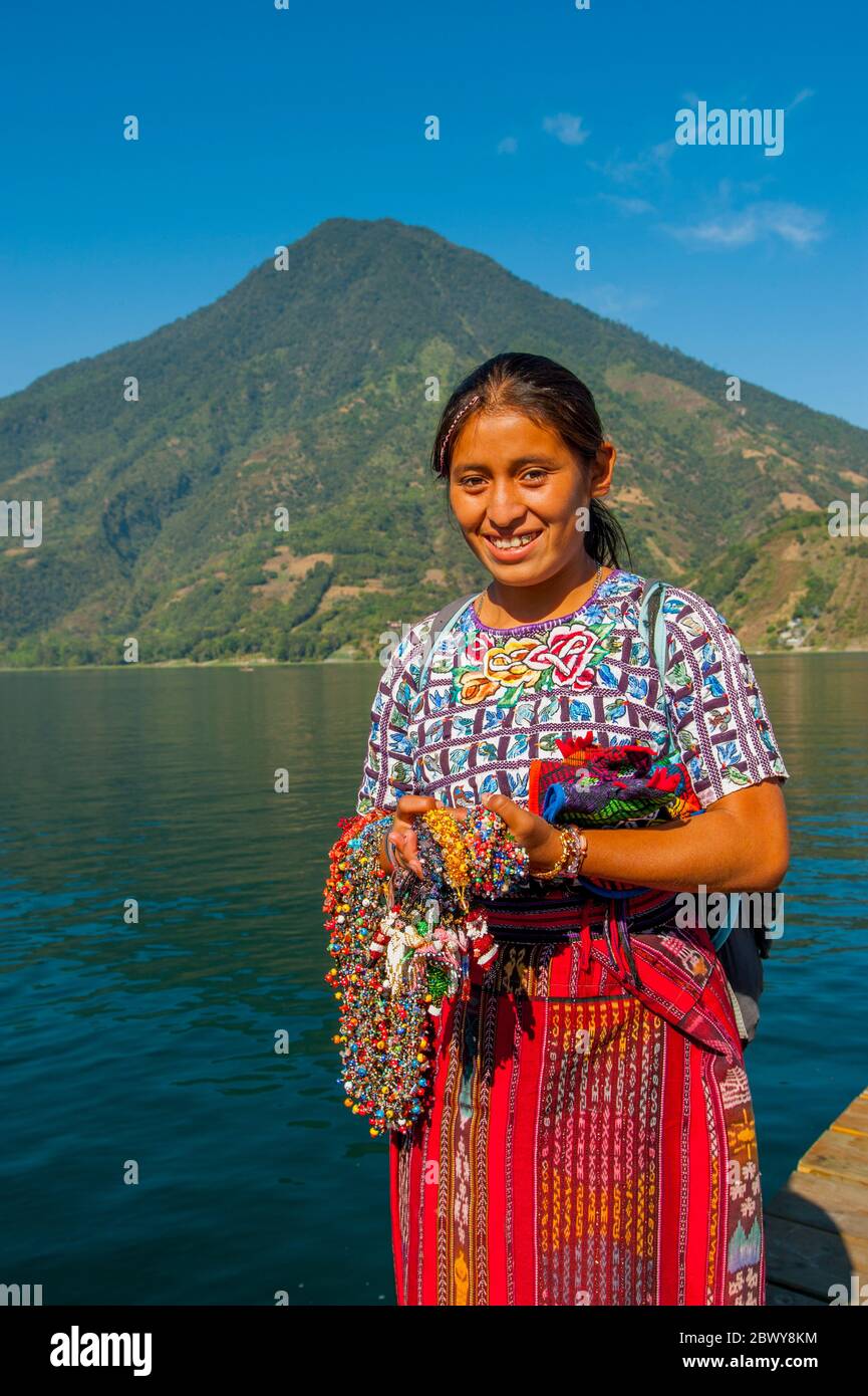 A young Mayan woman at Lake Atitlan with San Pedro Volcano near the town of Santiago in the southwestern highlands of Guatemala. Stock Photo