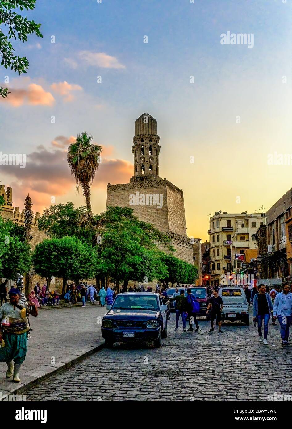 The massive Salient of the El Hakim Mosque Minaret towers above the outer walls of the city at the Southern end of Al-Muizz Street in Islamic Cairo Stock Photo