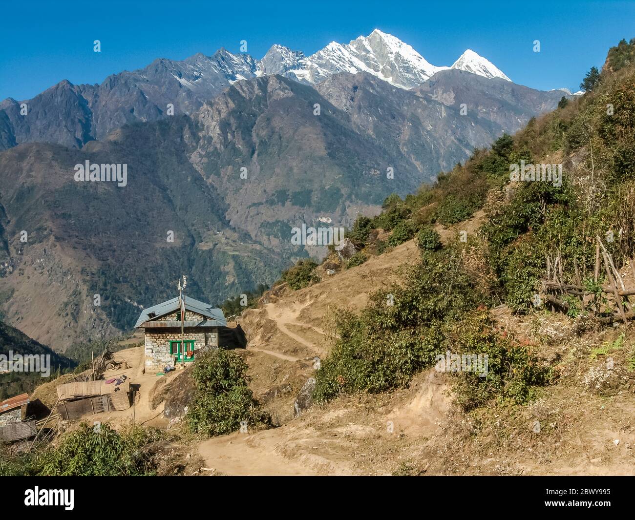 Nepal, Trek to Mera Peak. Trek trail above Lukla village looking across to the Dudh Kosi gorge and the sacred peak of Kumbila. Stock Photo