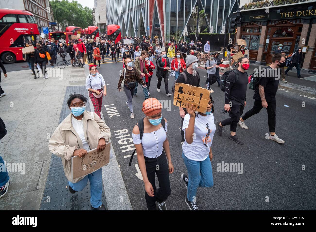 London, UK: June 3, 2020: Black Lives Matter protesters with signs walking from Westminster past Victoria Station Stock Photo