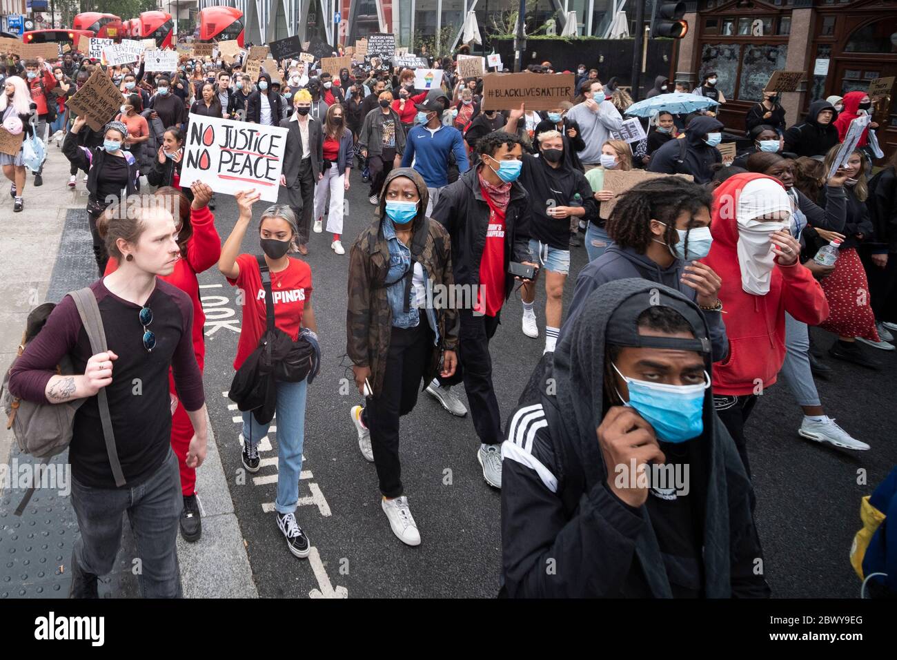 London, UK: June 3, 2020: Black Lives Matter protesters with signs walking from Westminster past Victoria Station Stock Photo