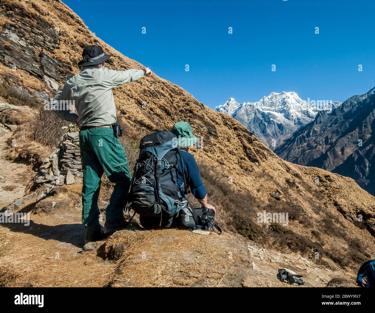 Nepal. Trek to Mera Peak. Trek trail above the Hinku Valley, en-route to Tangnag settlement with trekkers enjoying their first view of Mera Peak they have come to climb? Stock Photo