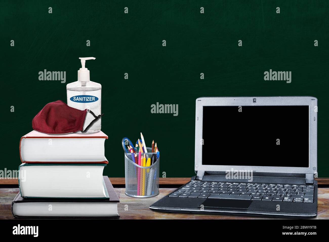Education back-to-school New Normal concept during Covid-19 pandemic in classroom with books, hand sanitizer, cloth face mask, laptop and pencil holde Stock Photo
