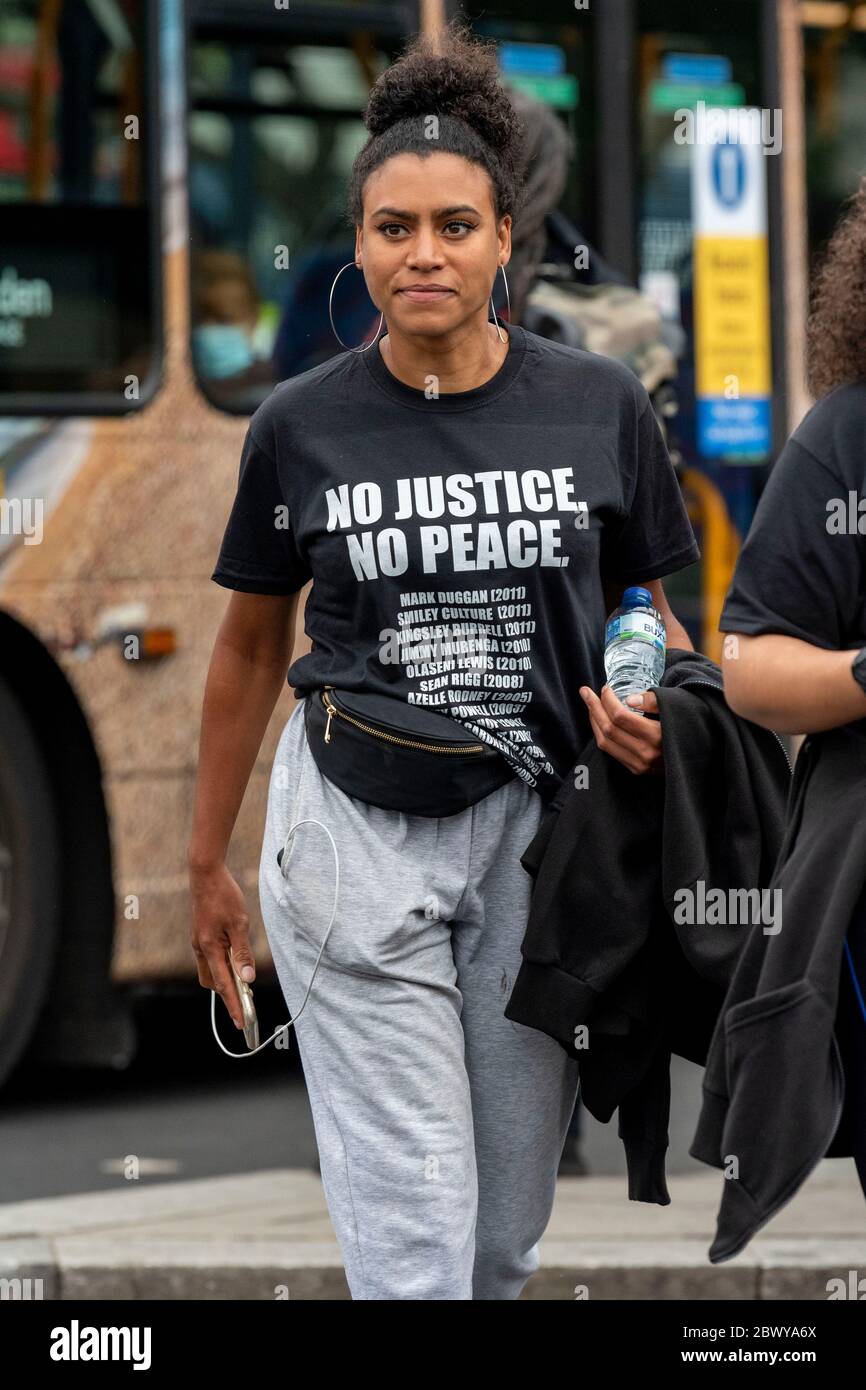 A woman wearing a 'No justice, no peace' T-shirt with the names of black  men who have died while in Police Custody during the Black Lives Matter  protest at Hyde Park.Several protest