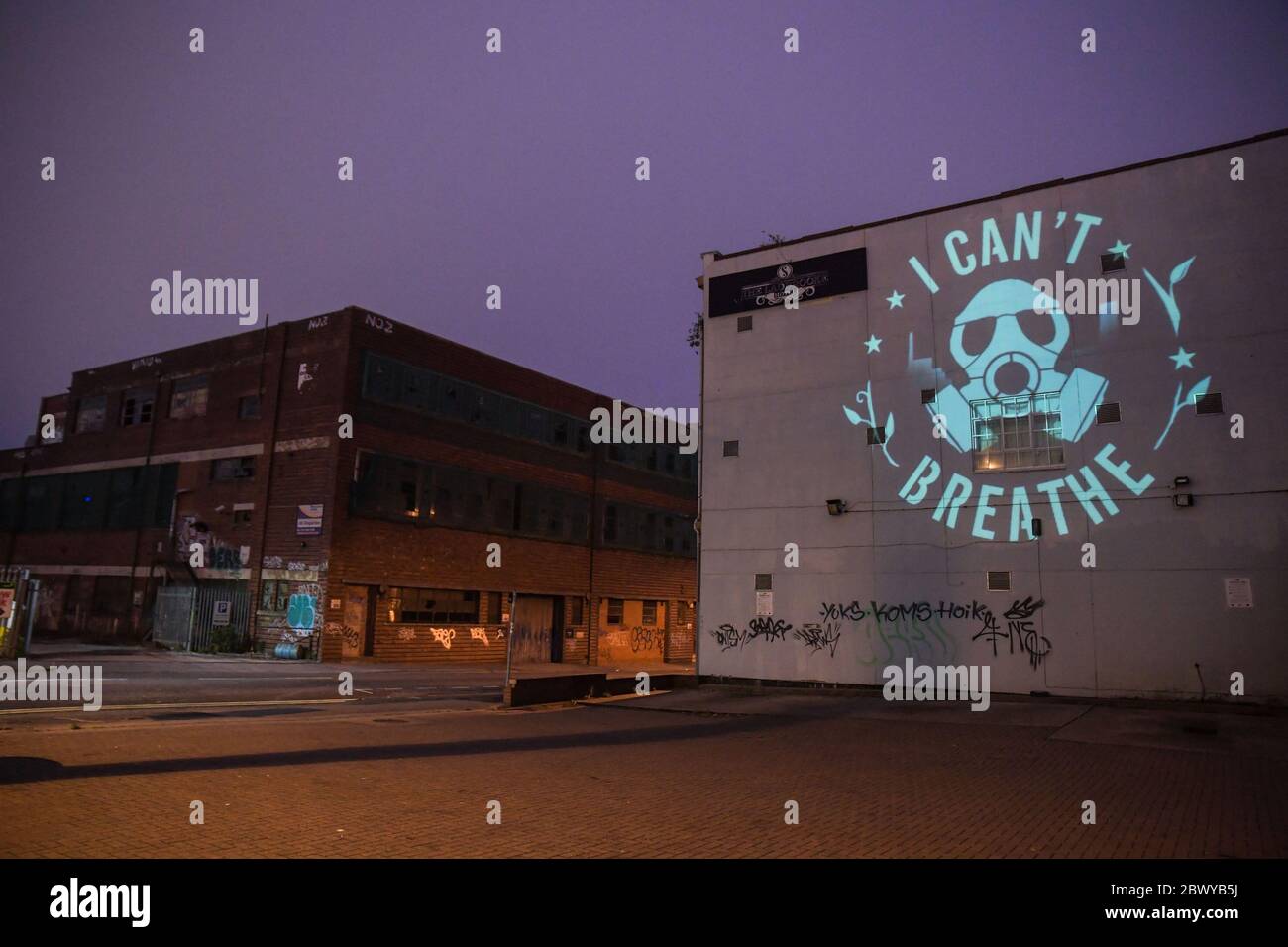 Birmingham, West Midlands, June 3rd 2020. George Floyd 'I Can't Breathe' statement artwork designed by Birmingham artist, Mohammed Ali Aerosol is projected on to the side of a Birmingham building in the Digbeth area of the city. David Whittall, who owns Suki10c, a pub opposite the artwork which is painted with 22 black stars of future of Birmingham. His pubs graffiti artwork is by Gent48. Whittall asked for permission to project the Floyd artwork. David said: 'We in the UK do not have to suffer the experience of a military-backed curfew enforced by baton, tear-gas, flash grenades and the viole Stock Photo