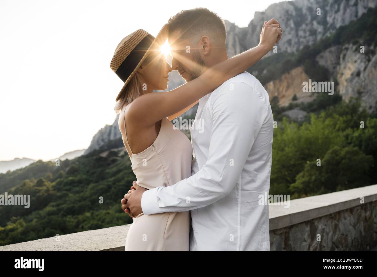 Young couple in love kisses in the rays of the setting sun. Stock Photo