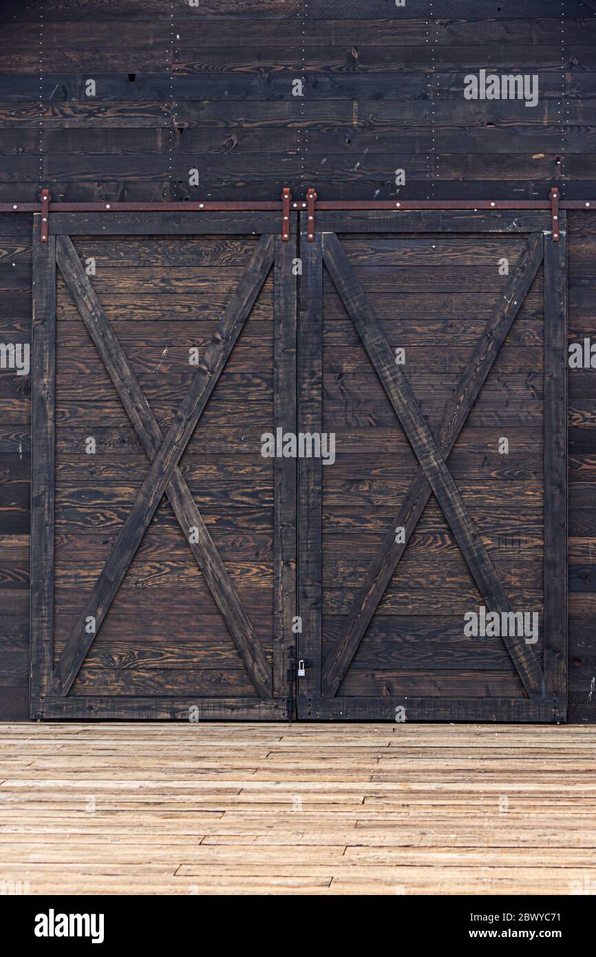 large sliding barn doors built with dark reclaimed wood Stock Photo Alamy