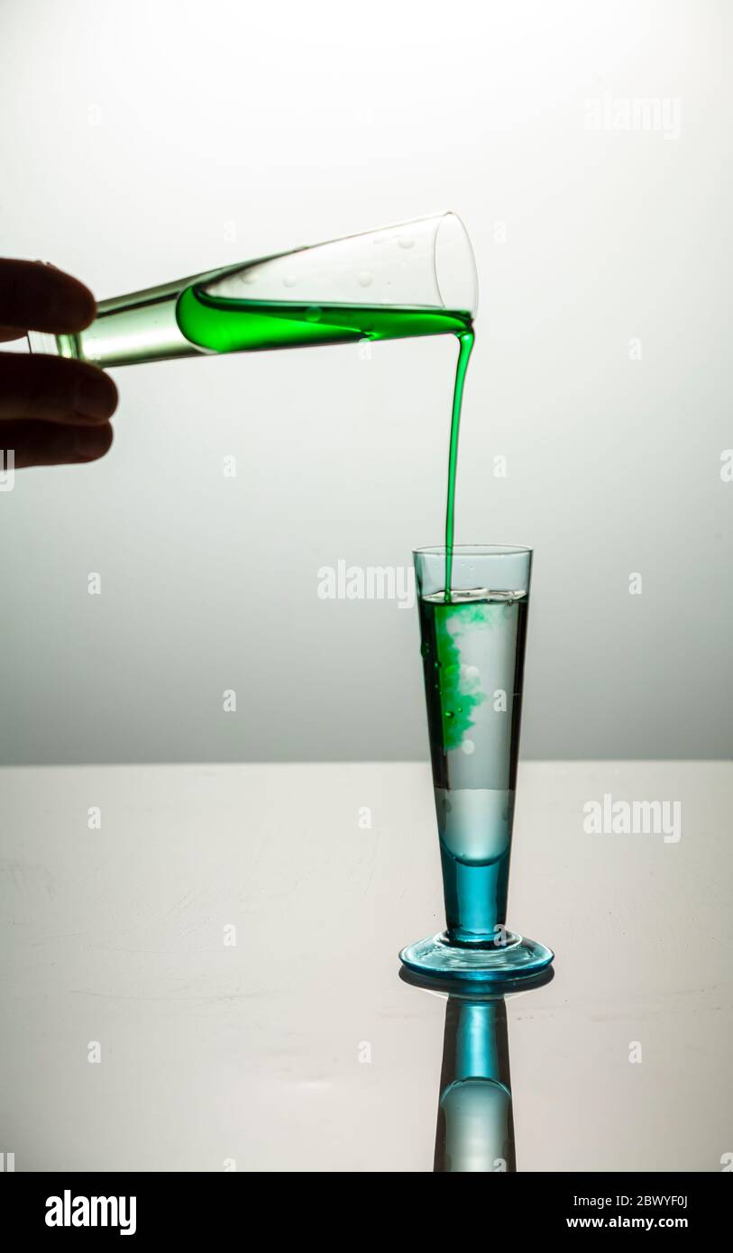 Pouring different color liquids into glasses Stock Photo Alamy