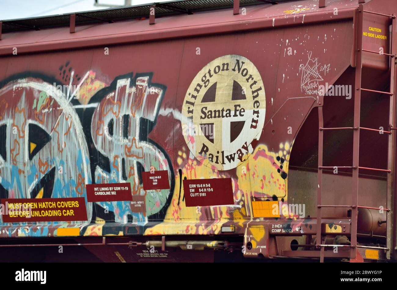 Franklin Park, Illinois, USA. A Burlington Northern Santa Fe freight car  within a freight train defaced by graffiti. Stock Photo