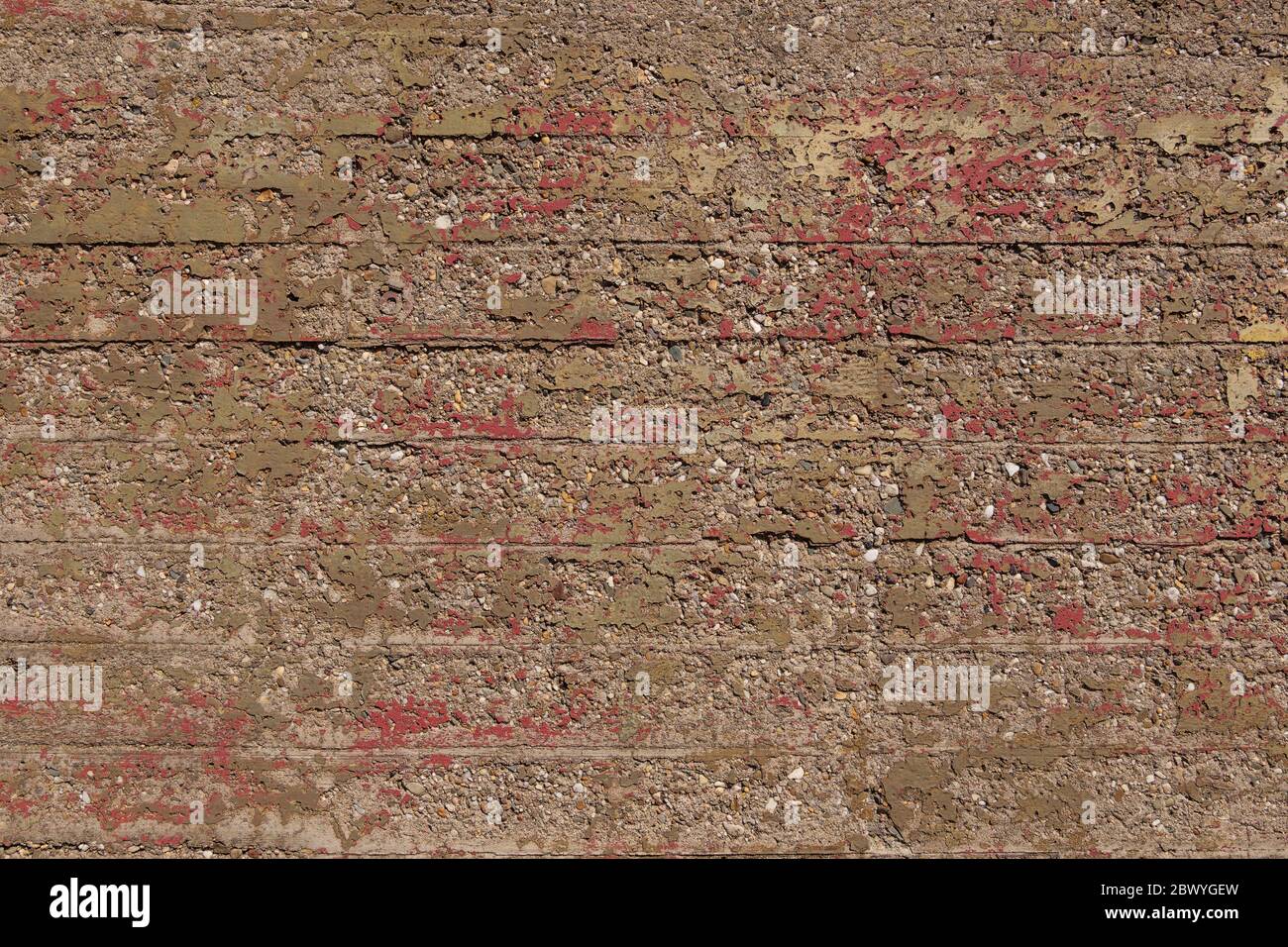 Old Raw grunge rough bumpy concrete texture with remaining scratch of red painted and corrosive surface. Texture of exterior old bunker. Stock Photo
