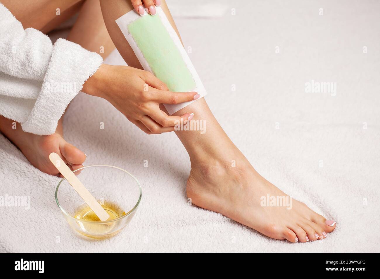 Woman uses wax tape to remove hair on legs Stock Photo Alamy