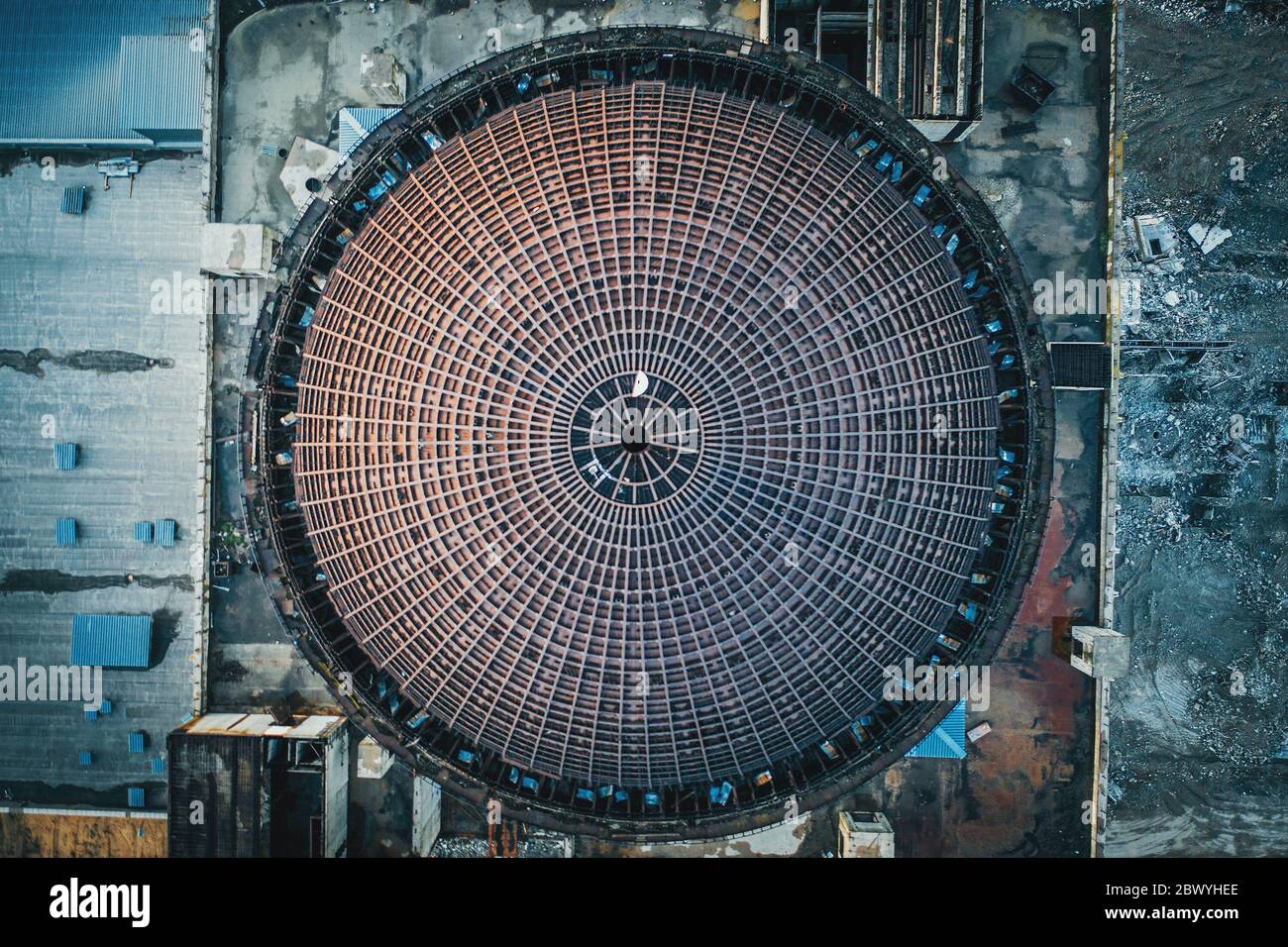 Above round iron roof of unfinished nuclear power plant, circle metal construction, industrial building, aerial top view. Stock Photo